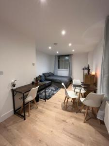 a living room with a table and chairs and a couch at Cosy Maidstone Flat near Station (Town Centre) in Kent