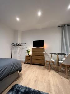 um quarto com uma cama, uma mesa e uma televisão em Cosy Maidstone Flat near Station (Town Centre) em Kent