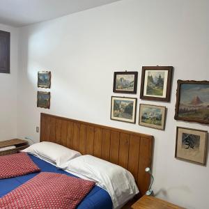 - une chambre avec un lit et des photos sur le mur dans l'établissement appartamento Cervinia fronte Funivie CIR 0480, à Breuil-Cervinia