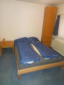 łóżko z niebieskimi poduszkami w pokoju w obiekcie Großhof w mieście Lenzkirch