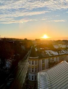 a view of a building with the sunset in the background at Frogner Park Penthouse Terrace in Oslo