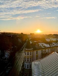 een uitzicht op een gebouw met de zonsondergang op de achtergrond bij Frogner Gården Penthouse Terrasse in Oslo