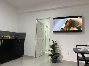 uma sala de estar com uma televisão de ecrã plano na parede em HHC Apartments Kronos em Paramaribo
