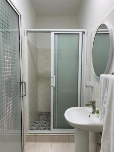 uma casa de banho com um chuveiro e um lavatório. em HHC Apartments Kronos em Paramaribo