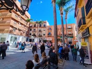 a crowd of people walking down a street with palm trees at Apartamento Estudio VERDE in Almuñécar