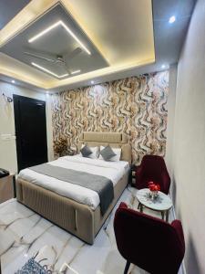 a bedroom with a bed and a couch and a table at Crescent Inn in Greater Noida