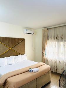 um quarto com uma cama grande e uma janela em OD-V!CK'S LUXE, Wuse Zone 4, Swimming Pool, Gym, WiFi, 24hr power, security, Dstv em Abuja
