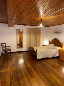 a bedroom with a large bed and a wooden ceiling at O Cabaleiro in Santa Marta de Ortigueira