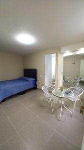 Habitación con cama, mesa y sillas. en Aristides Inn, en Huarmey