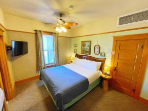a bedroom with a bed and a window and a television at Hotel Vendome in Prescott