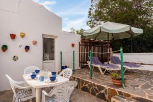 patio ze stołami, krzesłami i parasolem w obiekcie Apartamento El Shacko w mieście Arenal d'en Castell