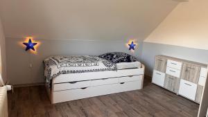 ein Schlafzimmer mit einem Bett und zwei Sterne an der Wand in der Unterkunft FeWo-Busche, Doppelhaushälfte mit Garten in Wittmund