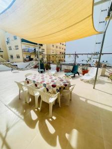 een patio met een tafel en stoelen op een dak bij Gran apartamento en el centro Villajoyosa - Vistas al mar, 5 dormitorios y enorme terraza in Villajoyosa