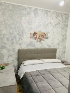 a bedroom with a bed with two pictures on the wall at casa giorgia mondello in Palermo