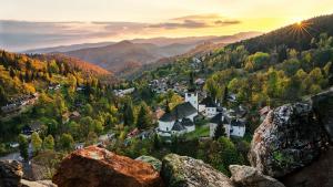 una pequeña ciudad en las montañas con la puesta de sol en Komfortný apartmán s bazénom a súkromným parkoviskom-NONSTOP Check-in, en Banská Bystrica