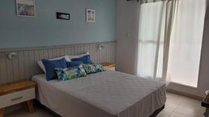 Una cama con almohadas azules en un dormitorio en Hotel el huerto 