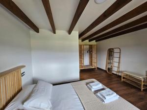 a bedroom with a bed with two towels on it at Casa Gure Amets - Costa da Morte in A Coruña