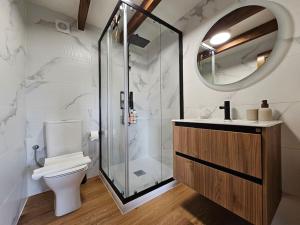 a bathroom with a toilet and a glass shower at Casa Gure Amets - Costa da Morte in A Coruña +48 photos