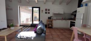 cocina y sala de estar con sofá y mesa en El Huertecito, en Navarredonda de Gredos