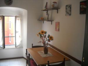 a dining room table with a vase of flowers on it at Giada Apartment in La Spezia
