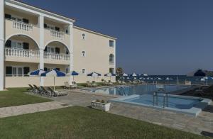 a hotel with a swimming pool in front of a building at Maria Mare Apart-hotel in Argassi