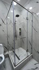 y baño con ducha de cristal y aseo. en ЖК Green Plaza, en Aktau