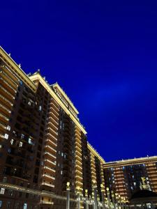 un edificio alto por la noche con un cielo azul en ЖК Green Plaza, en Aktau