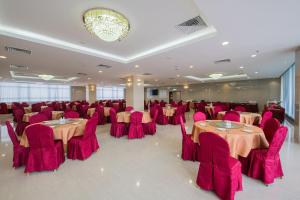 a banquet hall with tables and chairs and a chandelier at Grand InHotel in Kota Kinabalu