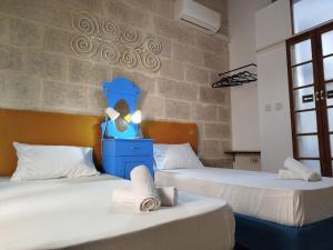 two beds in a room with two towels on them at Limestone Sun Suites in Sliema