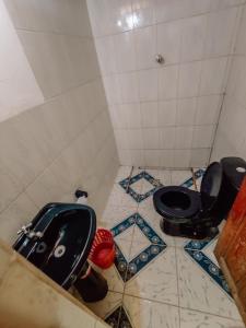 a bathroom with a black toilet and a sink at Hostal Isla del Sol in Comunidad Yumani