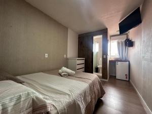 a bedroom with a bed and a dresser and a mirror at Recanto da Sol in Florianópolis