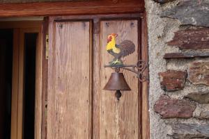 una puerta de madera con un gallo en una campana en Los Castaños, Vivienda Rural, Capileira en Capileira