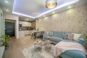a living room with a blue couch and a kitchen at LaVida Deluxe villa Hajdúszoboszló in Hajdúszoboszló
