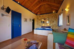 a living room with a blue door and a table at Villas Cavo Marathia in Keri