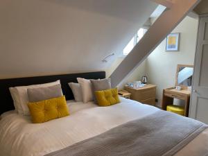 a bedroom with a large bed with yellow pillows at Ashbourne House in York