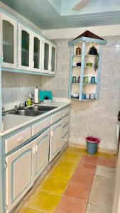 a kitchen with white cabinets and a sink at Caribbean Paradise steps to DayPass Resort&Beach in La Laguna