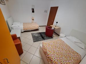 Habitación con 2 camas, mesa y espejo. en Lunga Via Delle Dolomiti, en Calalzo