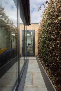 Una puerta de cristal de una casa con un sofá. en Cozy Leyton House with Garden and Small Terrace, en Londres