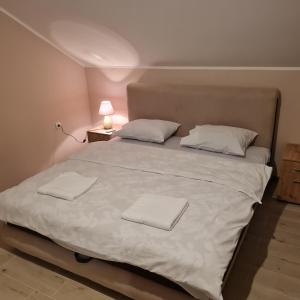 a large white bed with two white towels on it at Apartman Dalmacija in Ečka