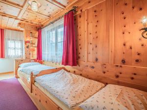2 Betten in einem Zimmer mit Holzwänden in der Unterkunft Andre Top 3 in Wald im Pinzgau