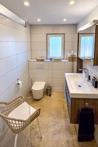 a bathroom with a toilet and a sink and a chair at Oliveres3 in L'Ampolla +68 photos