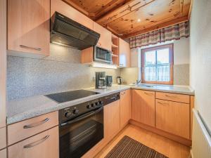 a kitchen with wooden cabinets and a stove top oven at Andre Top 3 in Wald im Pinzgau +5 photos