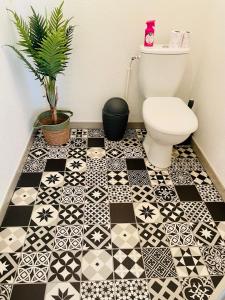 a bathroom with a toilet and a black and white tile floor at Appartement 2 chambres cosy proche aéroport et MEETT au pied du tram in Blagnac +14 photos
