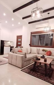 a living room with a white couch and a table at La Maisonette, Florina Center in Florina