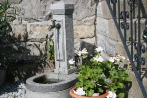 a stone fountain with flowers next to a stone wall at family & friends in Wernigerode