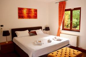 - une chambre avec un grand lit blanc et une fenêtre dans l'établissement Villa Bano Piemonte Private Pool, à Melazzo