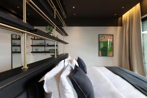Schlafzimmer mit einem Bett mit schwarzen und weißen Kissen in der Unterkunft The Modernist Athens in Athen