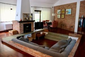 - un salon avec un canapé et une cheminée dans l'établissement Villa Bano Piemonte Private Pool, à Melazzo