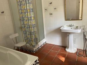 uma casa de banho com um lavatório e uma cortina de chuveiro em maison de campagne avec grand lac et park arboré 