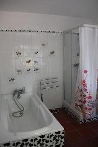 La salle de bains est pourvue d'une baignoire et d'une douche. dans l'établissement maison de campagne avec grand lac et park arboré, 